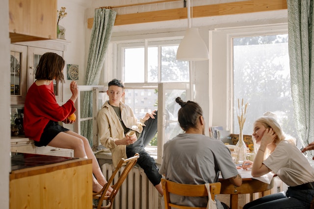 four roommates sitting in their kitchen chatting over coffee